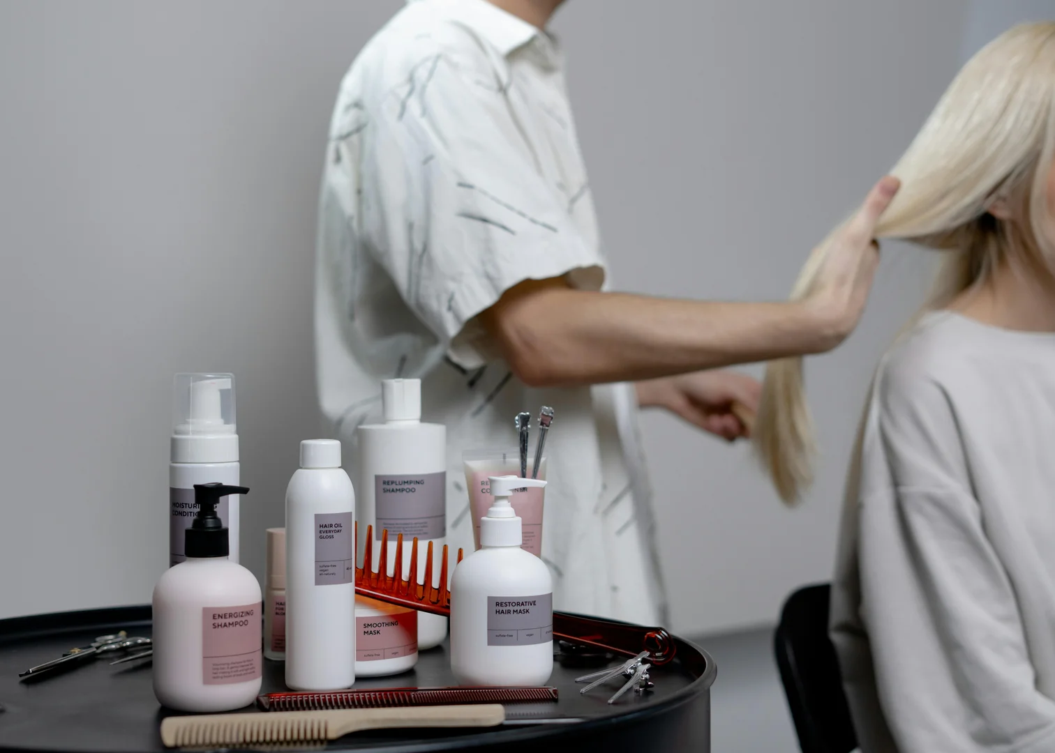Kenji reviewing notes beside a client during an in-salon consult
